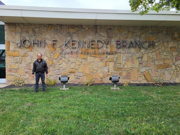 Photo of S. T. in front of the John F. Kennedy branch of the Muncie Public Library