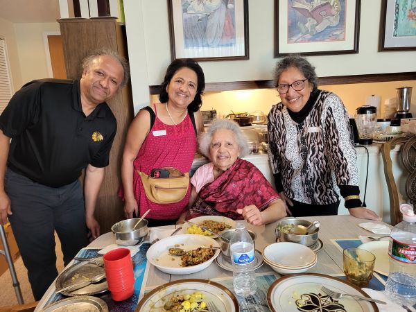 A photo of S. T. with his mother, two sisters, and a toothsome feast of Indian dishes