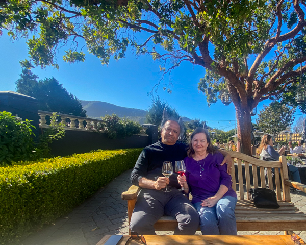 Photo of S. T. and Mary sitting under a sheltering tree at a beautiful winery