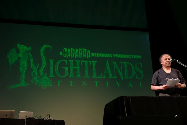 S. T. Joshi speaking at the Nightlands Festibal 2023 backed by the festival logo